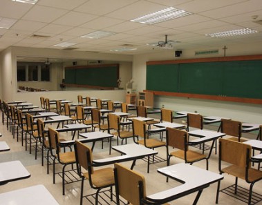 A classroom lined with desks sits empty.