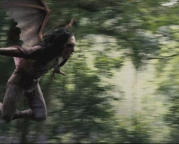 A winged primeval looking creatue flies through the air in a jungle setting.