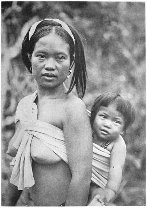 An Ifugao woman carries her child on her back using a carefully wrapped blanket.