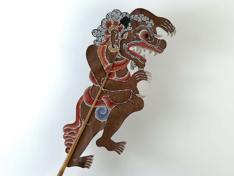 A creatures shadow puppet with claws and fangs, meant to represent the Rakshasa of Indian myth.