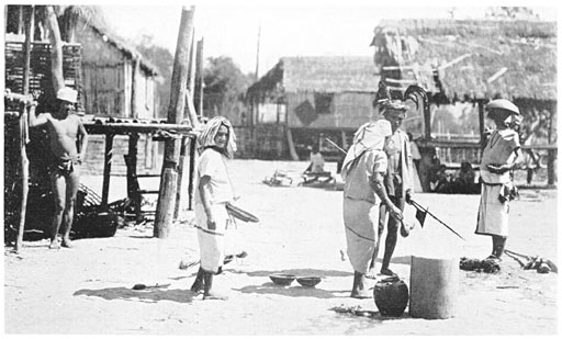 streetscape of a 1950's Tingguian village, with a few inhabitants performing a ritual. The streets are dirt and the houses are made of bamboo and thatching from leaves.
