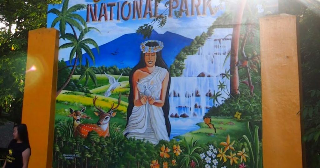 The Mount Arayat National Park sign embraces the legend of Maria Sinukuan in this beautifully painted image of a maiden with long black hair and a white gown connecting with nature and animals. 