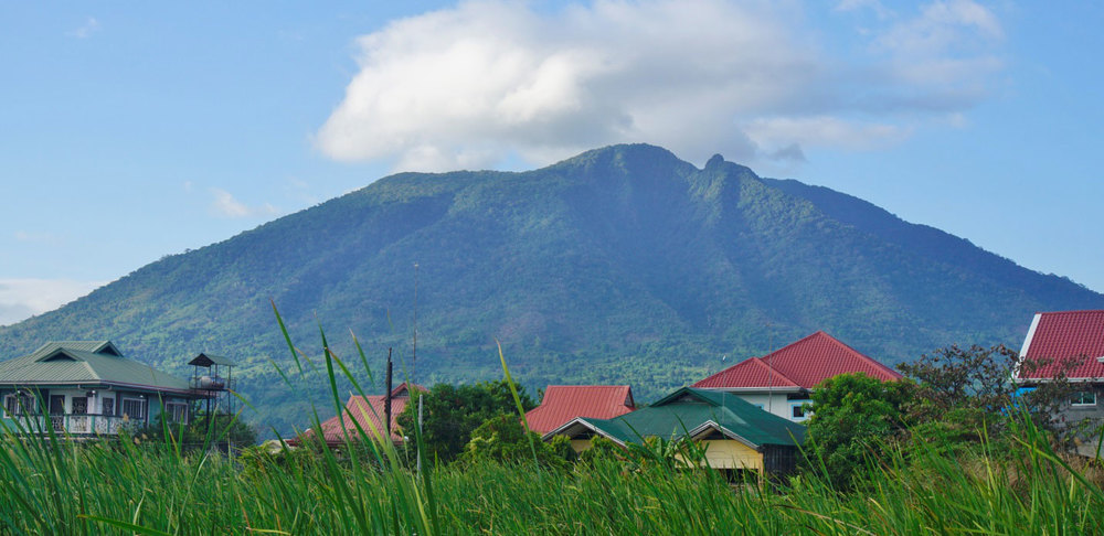Mount Arayat rising above a small village in the foreground. 