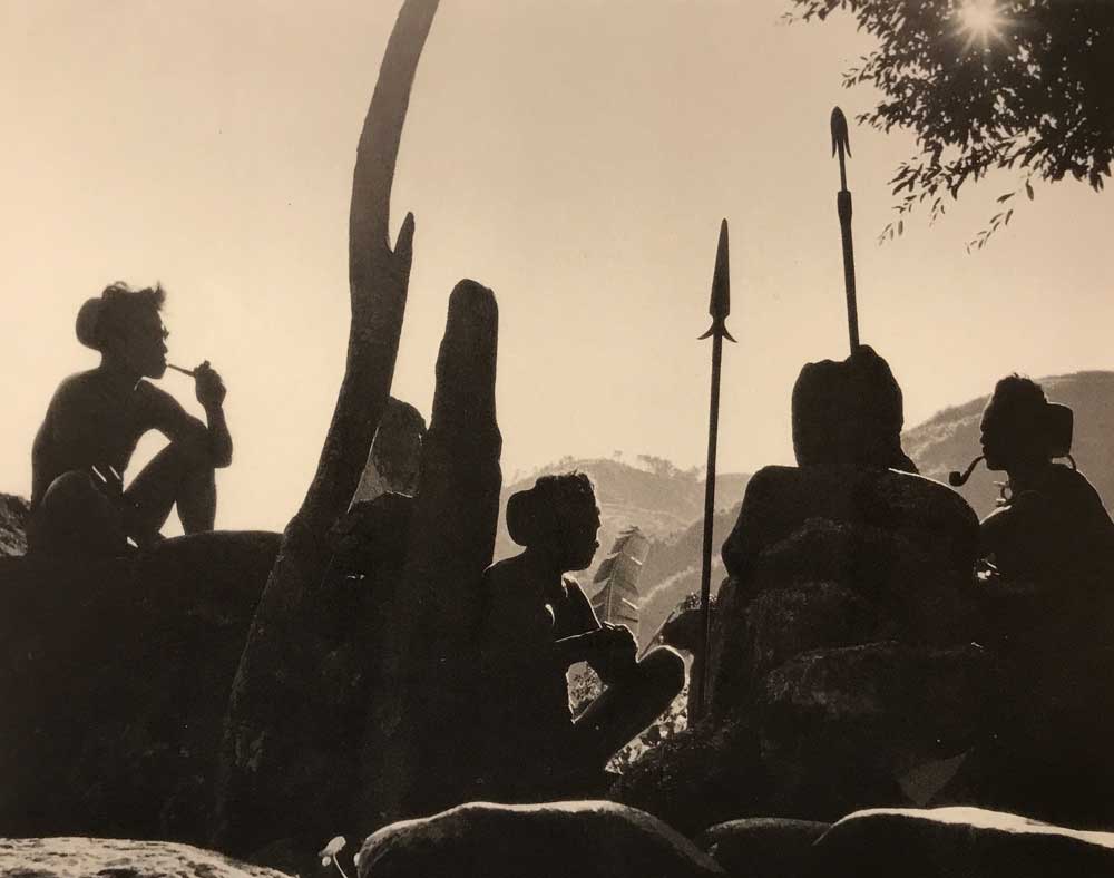 The silhouette of Bontoc men and their weapons are seen against the Mountain Province background. 